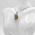 Unakite crescent moon face pendant with silver chain on a white mannequin display - Unakite