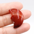 Carved red agate moon face gemstone ornament with natural striped texture and polished finish - Red Agate