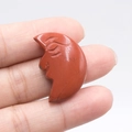 Red jasper carved crescent moon with face held in hand for spiritual decoration - Red Jasper