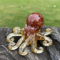 Octopus figurine with red agate stones and gold foil details on a rock - Red Agate