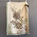 Dettaglio del motivo floreale vintage e delle nappe a frangia su una sciarpa beige - 190*65cm / verde chiaro
