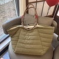Detail of olive green puffer tote bag featuring quilted texture and rope handles on a chair - Large / Bean Green