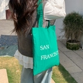 Outdoor shot of a green nylon tote bag with San Francisco print for casual daily use - Green