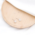 Elegante weiß-transparente Achat-Ohrstecker mit Silberstift auf einem Holztablett - Weiß Kristall