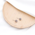 Elegante Ohrstecker aus grauem Naturstein Achat auf einem runden Holztablett - Grauer Achat
