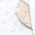 Set of 11 white crystal witch runes with engraved gold symbols on white fabric background - White Crystal