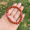 Skull bracelet with 8mm tiger eye beads and silver metallic spacers held in hand - Red Jasper