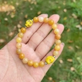 Yellow tiger eye beaded bracelet featuring skull charms and silver spacers on hand - Topaz