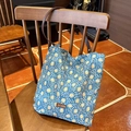 Donkerblauwe tote bag met gele sterrenprint en bruine leren riem op een houten stoel - Shoulder Bag / Blauwe Zonnebloem