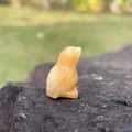 Miniature hand-carved yellow crystal owl figurine with natural mineral texture - Topaz