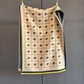 Détail d'une écharpe en maille à motif tête de cheval, bords verts et franges jaunes - Bordure Verte