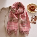 Dettaglio di sciarpa a quadri rosa con frange indossata su un cappotto di lana beige - 53x204cm / Rosa