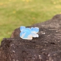 Mini 1-inch opalite squirrel crystal carving on natural raw stone with green background - Synthetic Opal