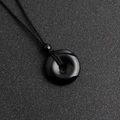 Polished black agate donut pendant with matching woven cord and decorative bead - Obsidian