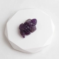 Handcrafted purple amethyst stone carving in animal shape on a geometric pedestal - Amethyst