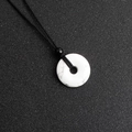 Ciondolo a ciambella in turchese bianco con venature naturali e cordino nero - Howlite
