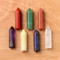 Set van zeven zeshoekige chakra-kristallen staven op rustieke houten achtergrond - Rode Aventurijn Stijl (Set van 7)