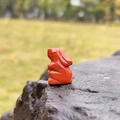 Hand-carved red jasper rabbit figurine with natural patterns on a stone surface - Red Jasper