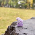 Hand-carved purple amethyst rabbit gemstone figurine on a natural rock background - Amethyst