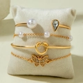 Detail of four-piece gold bracelet set with butterfly pendant and pearl embellishments - 4-Piece Pearl Butterfly Style(31728-bra-G-EP)