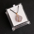 Halskette mit unregelmäßigem rosa Naturkristall und vergoldetem Rand in einer Displaybox - Heller Amethyst