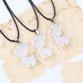 Three translucent milky white reindeer pendants with black leather cords on vintage paper - Synthetic Opal