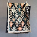 Detail of bohemian paisley shawl showing orange ikat pattern and fine fringe edges - Black