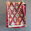 Close-up of retro geometric heart print scarf with detailed ethnic fringe and woven texture - Red