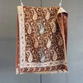 Close-up of paisley pattern and tassel trim on warm cashmere-feel pashmina shawl - Brown
