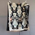 Détail d'un châle en maille à motif ikat avec motifs géométriques et pompons frangés - Noir