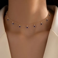 Elegante collar dorado con dijes de circón azul en una modelo con chaqueta color beige - Cadena Dorada Colgante Azul (23049-blue)