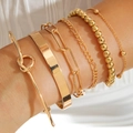 Close-up of 6pcs gold stackable bracelets with knot and link designs on female wrist - Paperclip And Figaro Chain Six Piece Gold Bracelet Set (30413-bra-G)