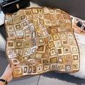 Close-up of geometric square print silk scarf on soft fur texture with luxury handbag - Brown