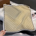 Close-up of elegant beige polka dot scarf on plush surface with fashion accessories - FW-166-White Border