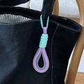 Minzgrüner und violetter gewebter Schlüsselanhänger an einer schwarzen Segeltuchtasche - Violetter Griff