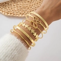 Dettaglio di un set di bracciali dorati con incisione LOVE e ciondoli a cuore al polso - Set da 6 pezzi con incisione LOVE e fiori (27989-G) / Oro