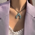Detail of bohemian turquoise horseshoe pendant on a black cord necklace worn by a model - Vintage Silver Turquoise Naja Pendant Necklace (25745-green)