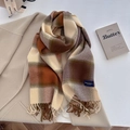 Detail of plaid scarf featuring fringed edges and elegant brand label on knit fabric - Brown