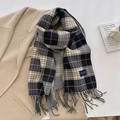 Sciarpa calda a quadri con nappe in nero e grigio posata su un cappotto beige - Nero (FYR-282-Nero)
