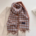 Detail eines karierten Schals mit orange-blauen Fransen und Elegant-Label - Blau