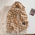 Details eines karierten Herbstschals mit Fransen und elegantem Label auf Blazer - Beige