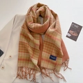 Dettaglio della sciarpa a quadri effetto cashmere con nappe su un blazer beige - Arancione Verde