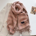Dettaglio ravvicinato di sciarpa a quadri rosa e marrone con nappe morbide ed etichetta chic - Rosa