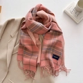 Dettaglio di una sciarpa in cashmere a quadri rosa con frange e etichetta elegante - Rosa