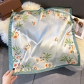 Detailed view of floral silk satin scarf with green border on elegant lifestyle props - 70cmx70cm / Peacock Green (W-433)