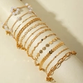 Detail of 8pcs golden bohemian bracelet set with pearls and charms on a round display - Gold 8-Piece Set (31110-bra-G-EP)