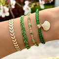Close-up of bohemian layered bracelets with gold leaf, green beads, and shell charm - Green (21255-A-green)