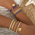 Detail of layered Bohemian bracelets featuring shell charms and colorful woven beads - Blue and White Set