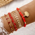 Detail view of Bohemian multi-layer bracelets featuring red beads and a gold shell charm - Red (21255-A-red)