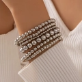 Detail van gestapelde zilveren kralenarmbanden over een witte geribbelde mouw - Zilver (25521-silver)